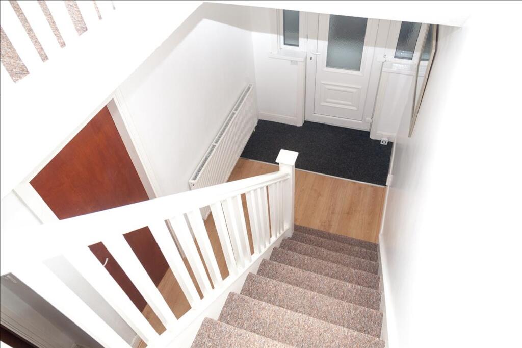 A well-lit staircase leading to the entrance, f...