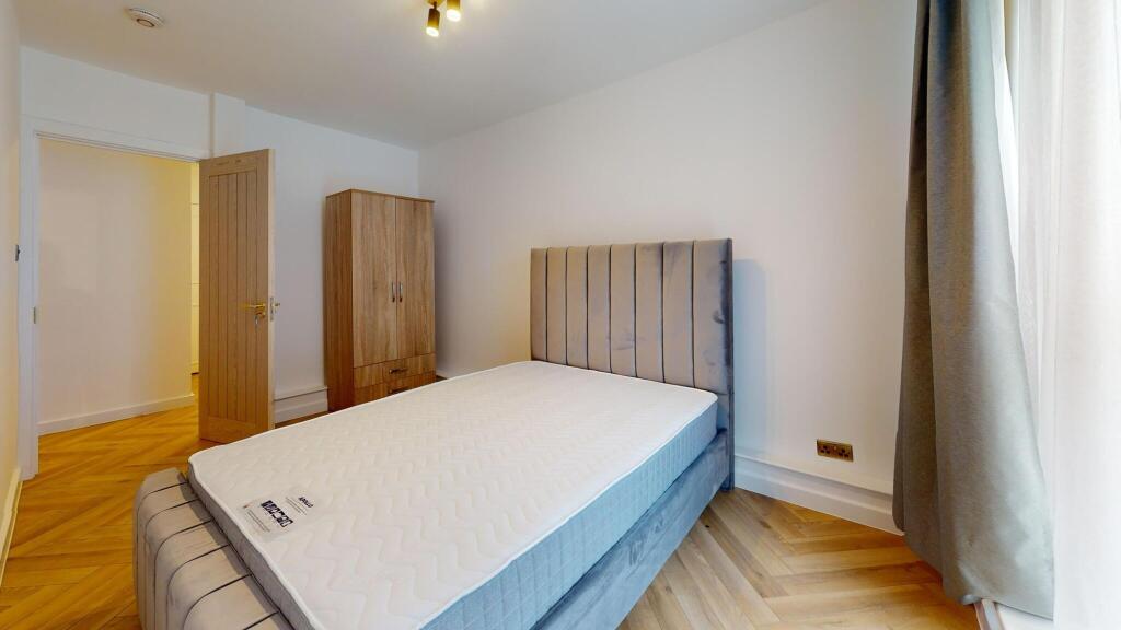 A bright and tidy double bedroom featuring a co...