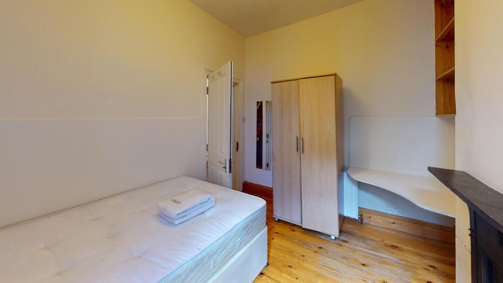 A neat and bright single bedroom featuring a be...
