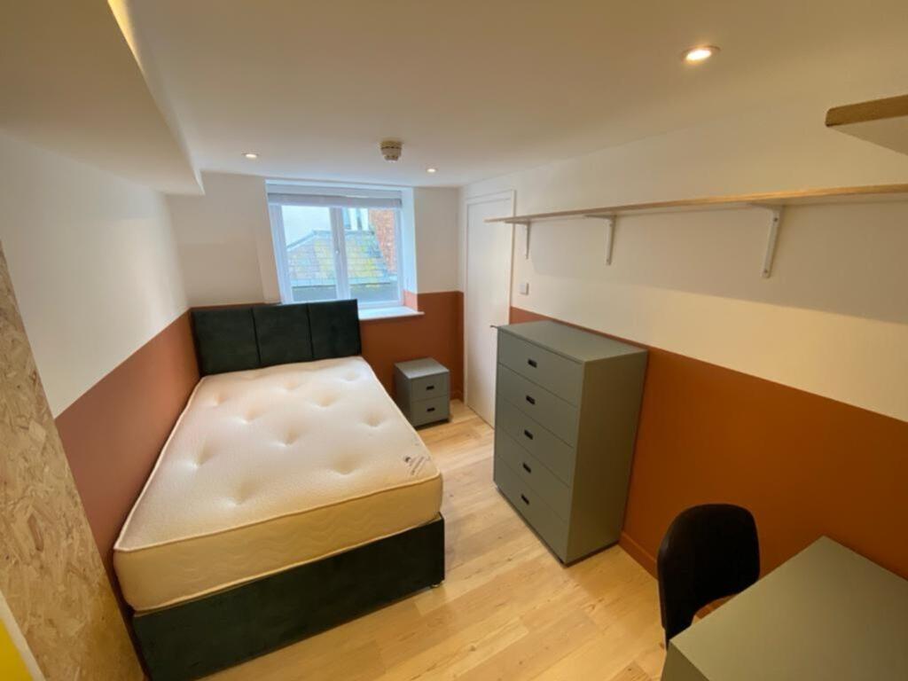 This spacious double bedroom features a comfort...