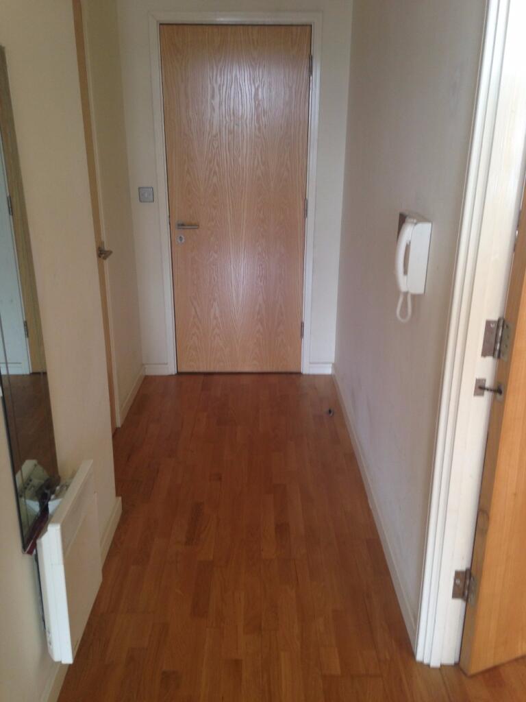 A clean and simple hallway featuring wooden flo...