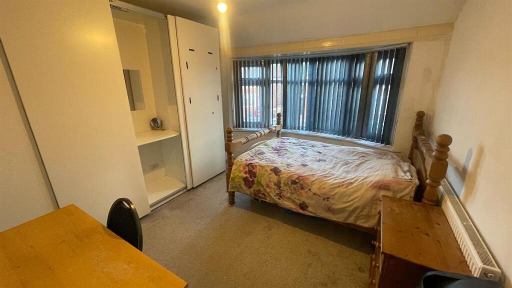 Bright double bedroom with a large window, buil...