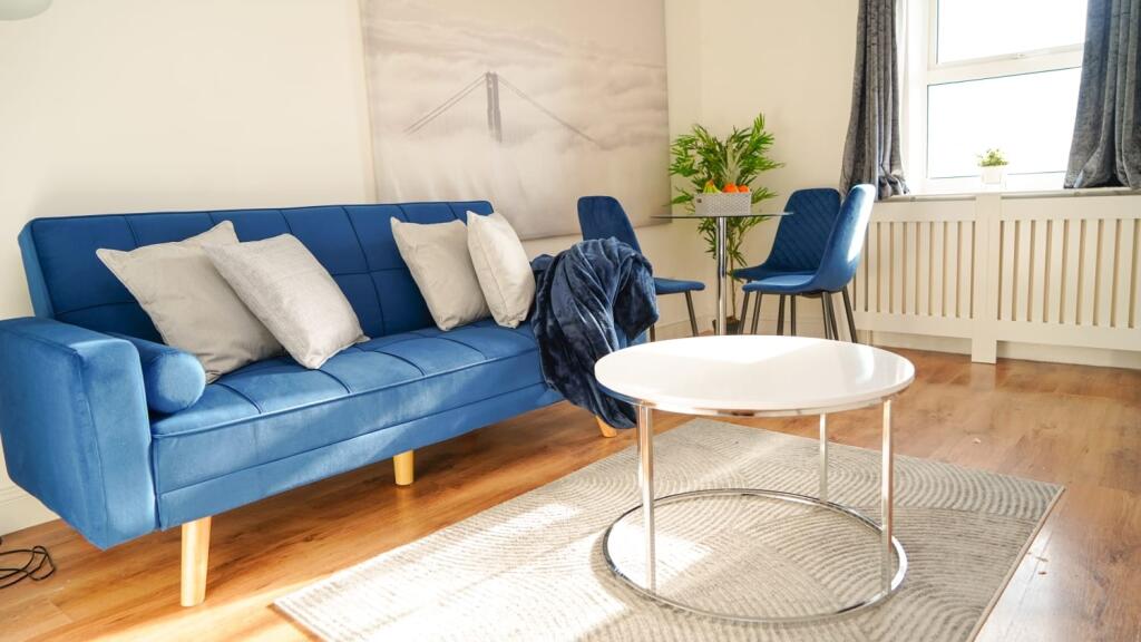 Bright and modern living room featuring a styli...