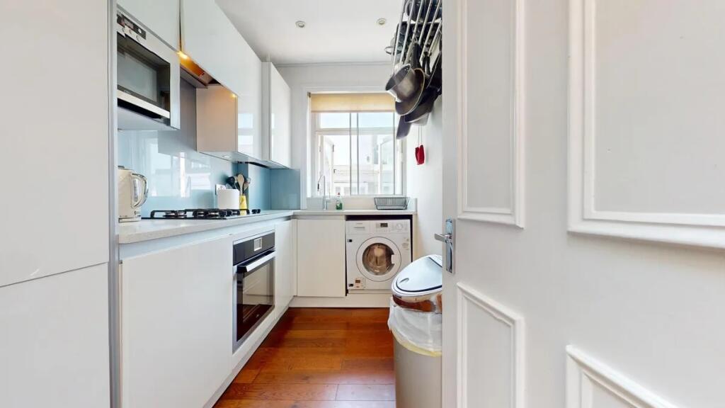 A sleek and modern kitchen featuring white cabi...