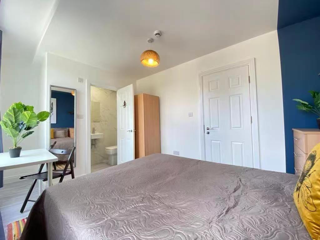 A spacious, well-lit master bedroom featuring a...