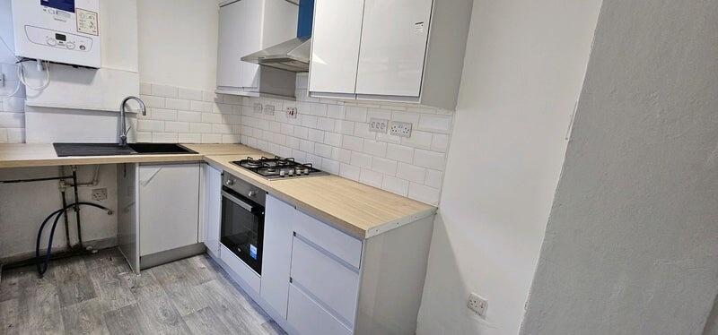 Modern kitchen with sleek white cabinets, wood-...