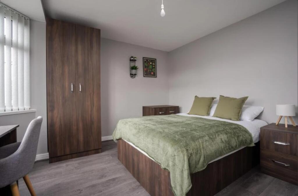 This inviting double bedroom features a comfort...