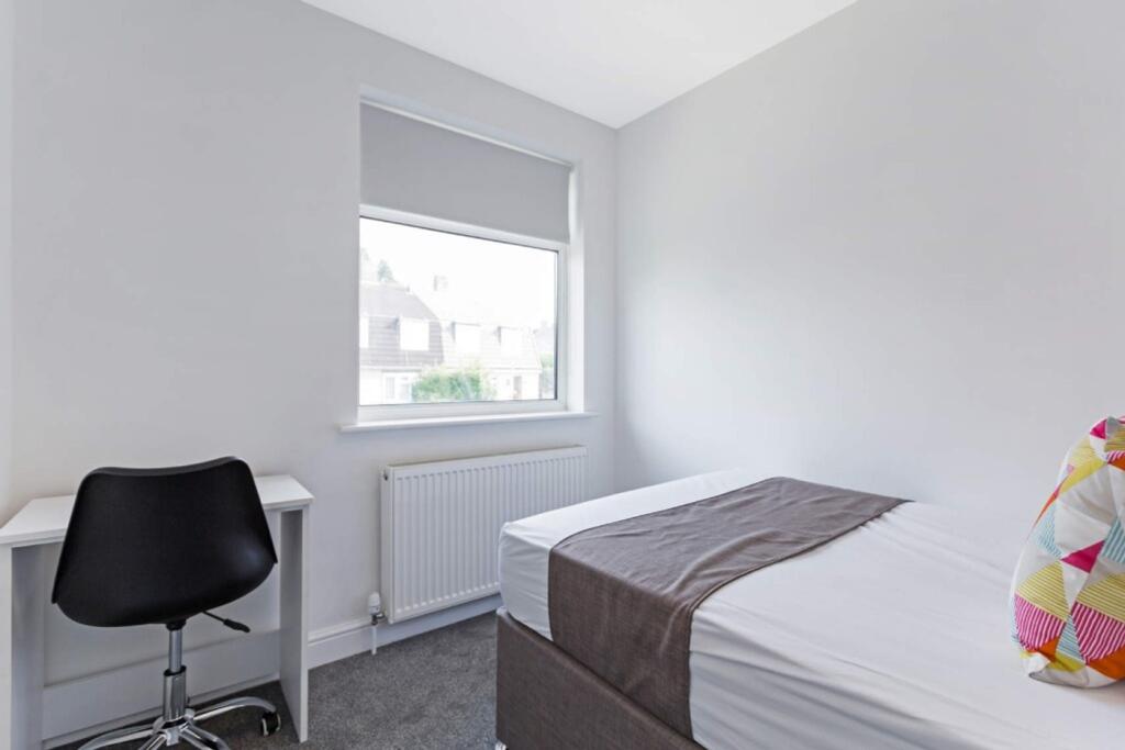 A bright and tidy double bedroom featuring a co...