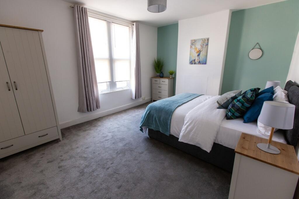 A bright and clean double bedroom featuring a c...