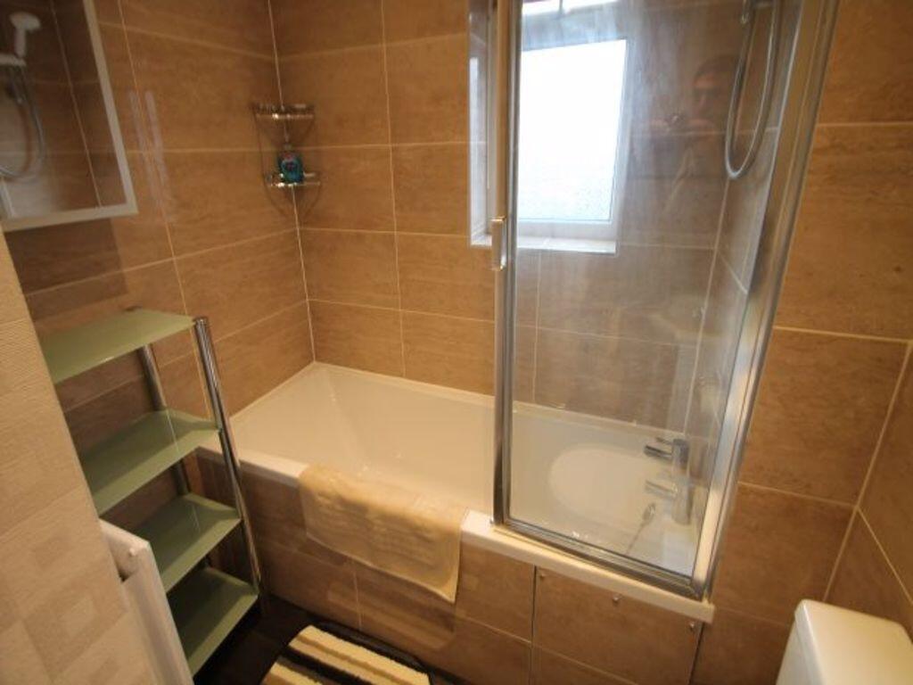 Bright, modern bathroom with tiled walls, combi...