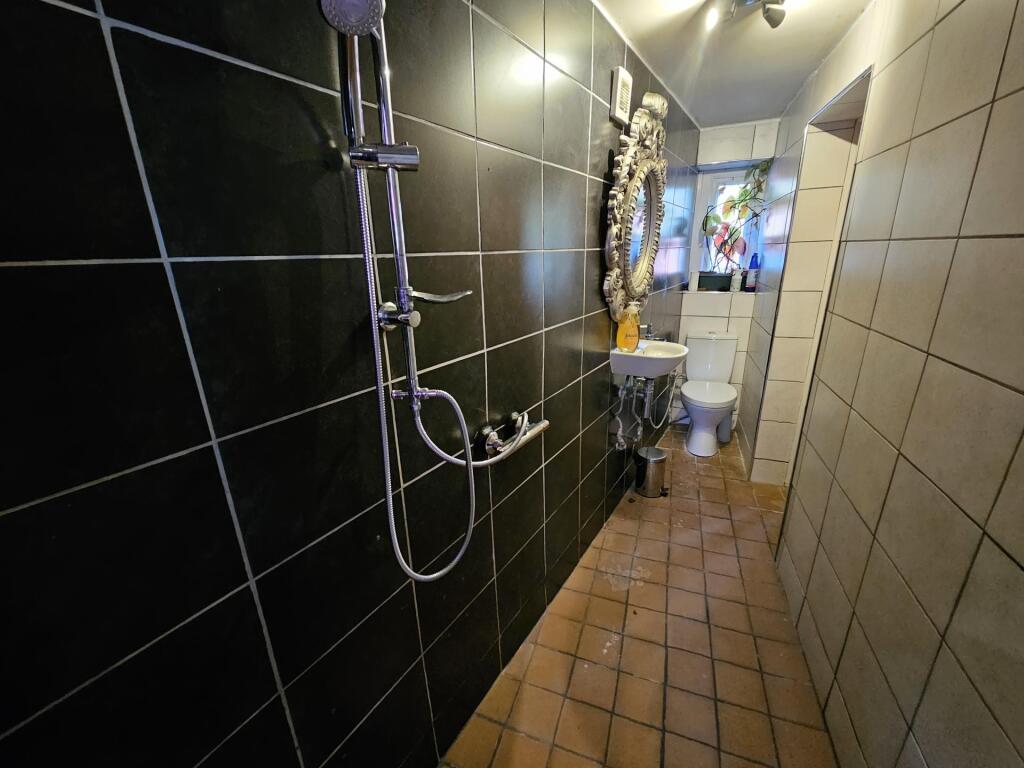 A modern bathroom with a large shower area, fea...