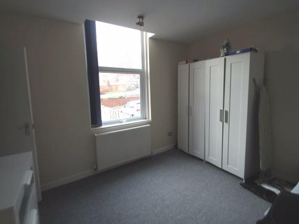 Bright, neutrally decorated bedroom with a larg...