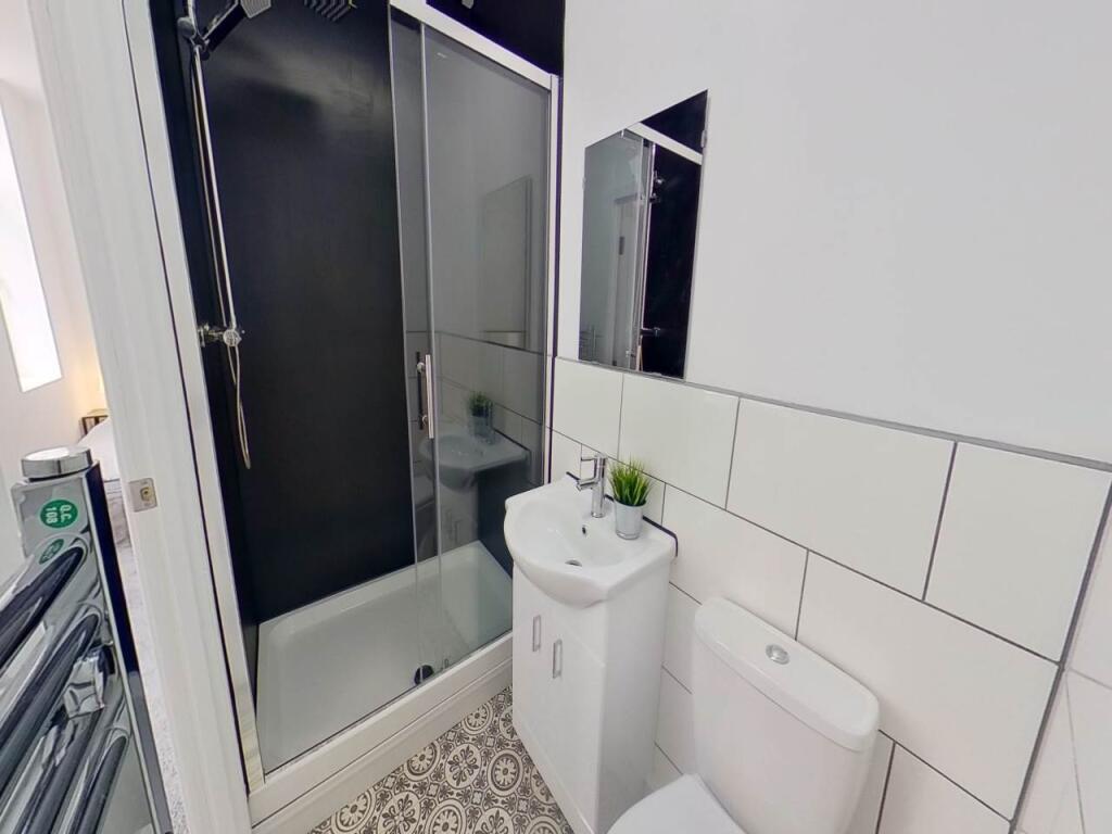 A clean, well-maintained bathroom with a shower...