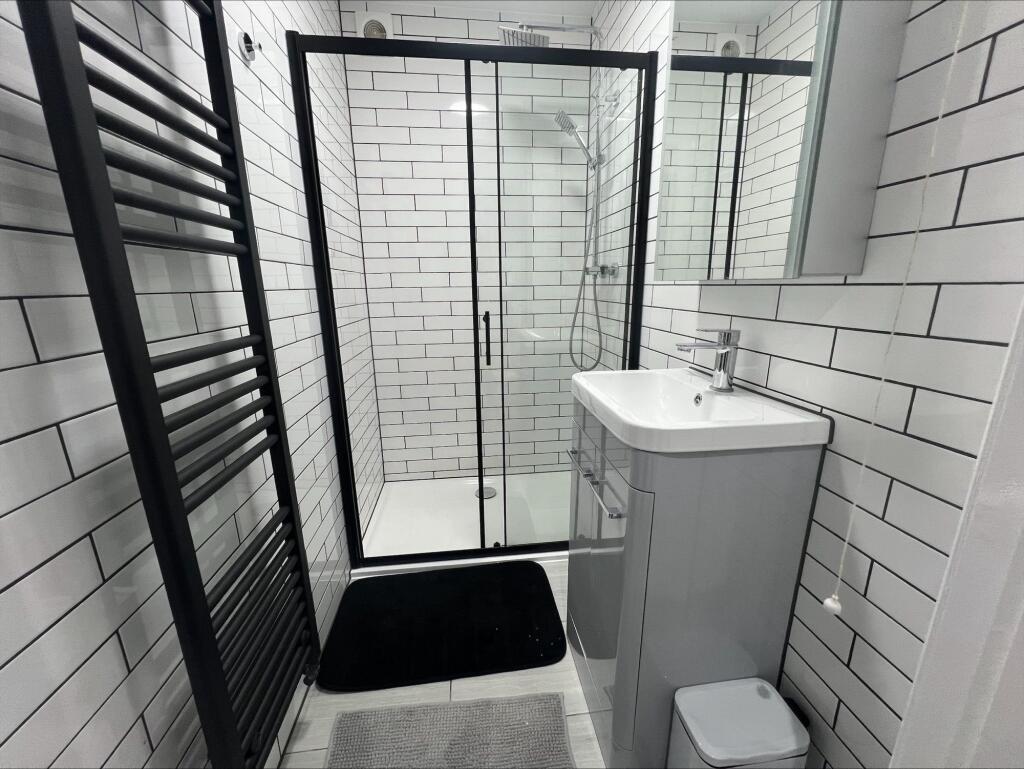 Modern bathroom featuring sleek white subway ti...