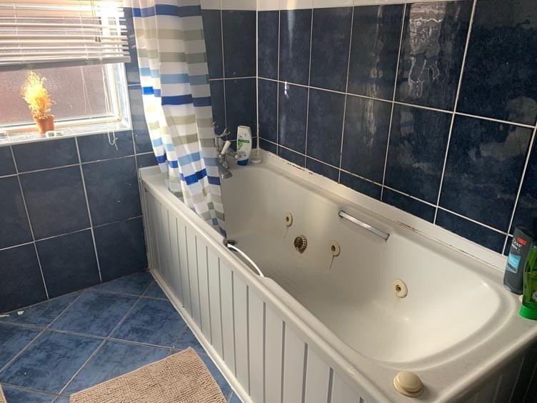 A spacious bathroom featuring a large bathtub w...