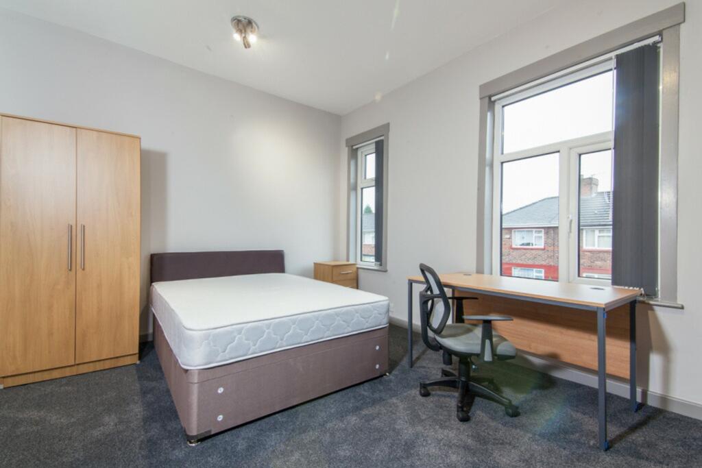 A spacious and inviting double bedroom with amp...
