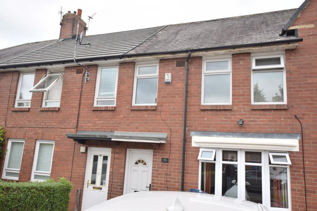 A well-maintained terraced brick house with whi...