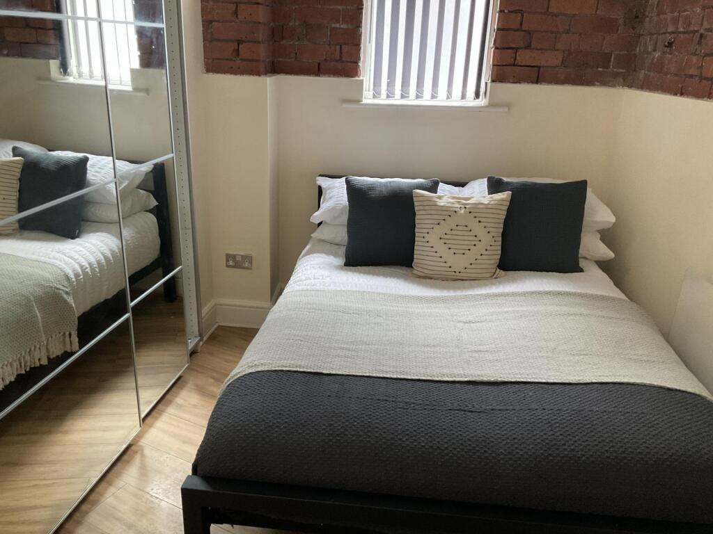 A cozy and well-kept double bedroom featuring a...