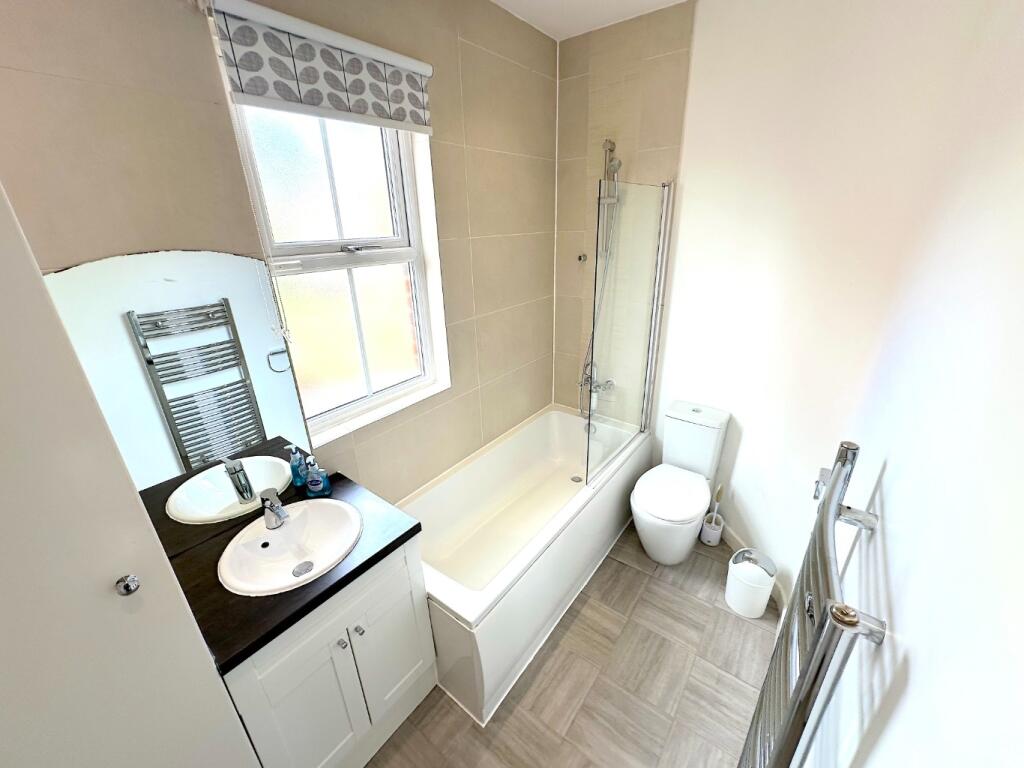 Bright, modern bathroom with a fitted bath and ...