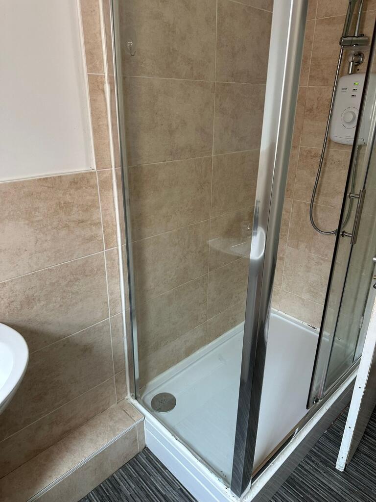 A clean and modern bathroom with a spacious sho...