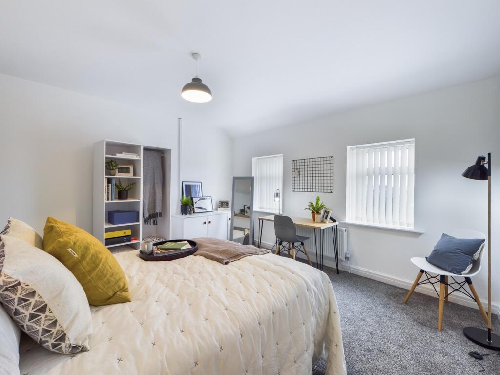 A spacious and inviting double bedroom with amp...