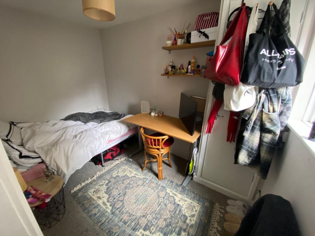 A cozy single bedroom featuring a comfortable b...