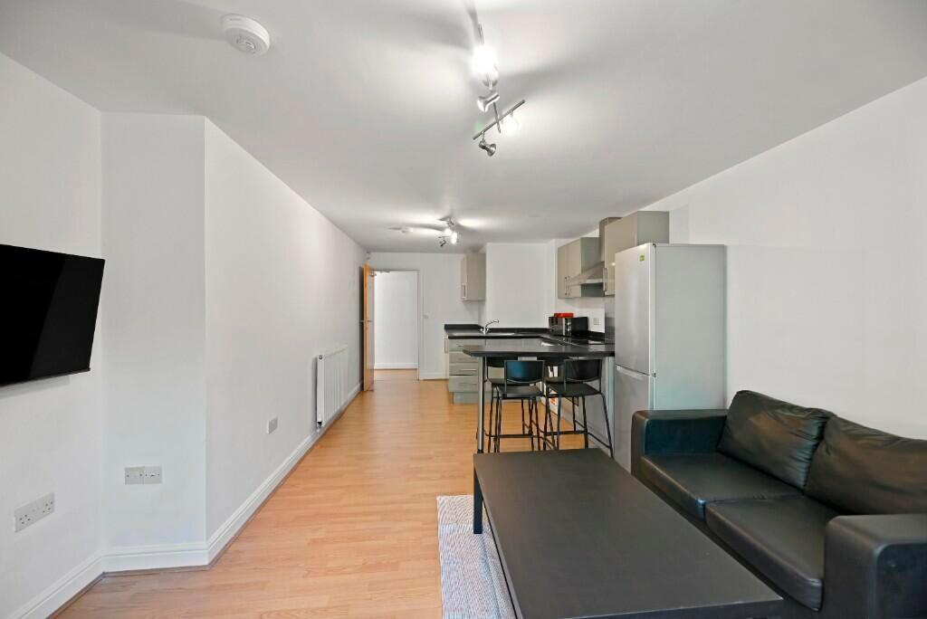 A modern and tidy open-plan living room featuri...