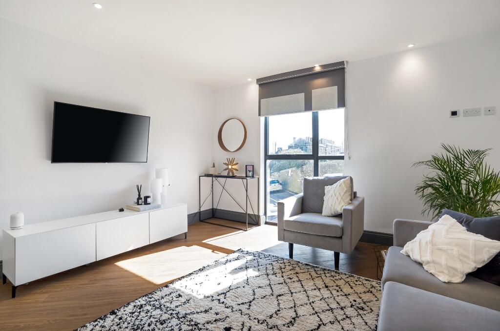 Bright and modern living room featuring a large...