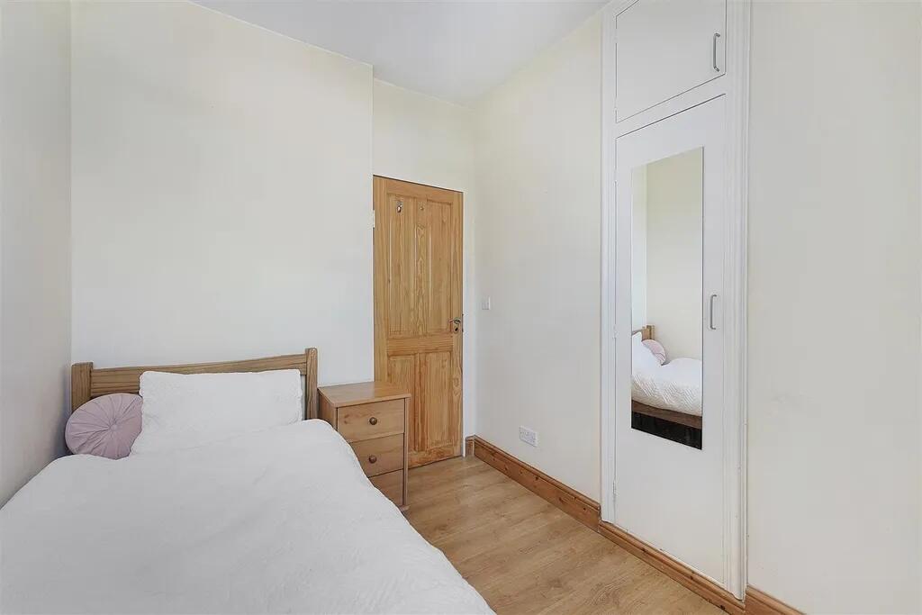 A neat and bright single bedroom featuring ligh...