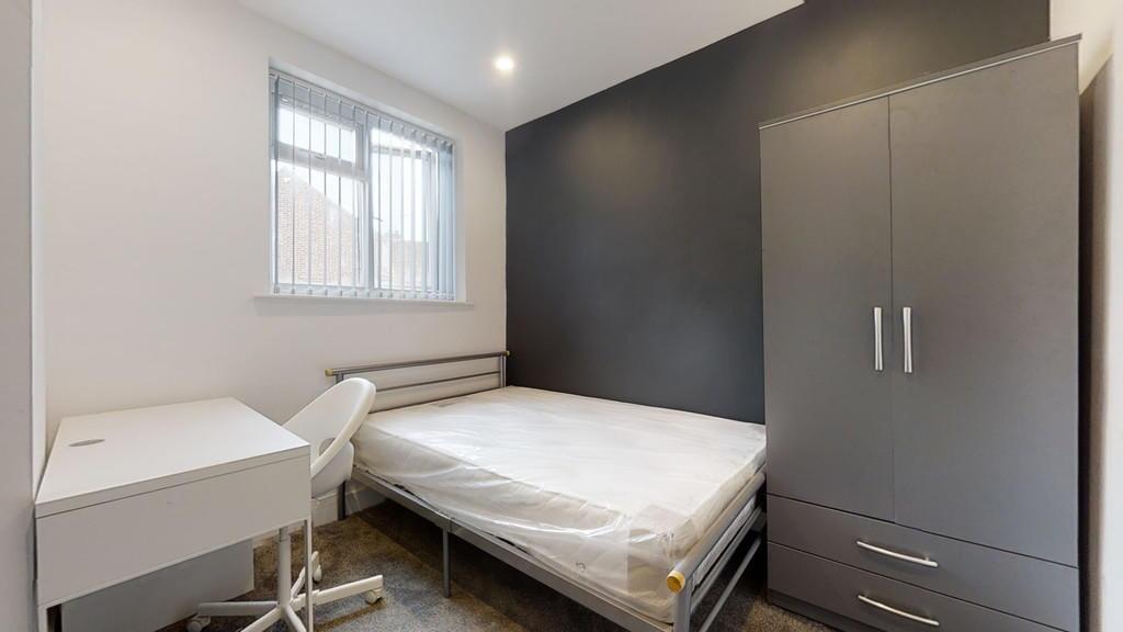 A neat and modern single bedroom featuring a co...