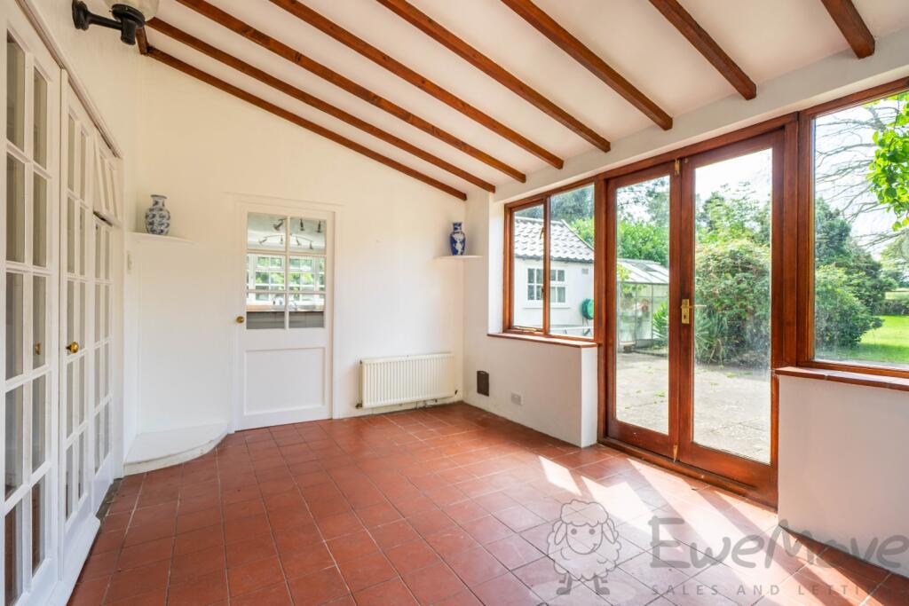 Sun Room Leading to Patio Driveway and Outbuilding