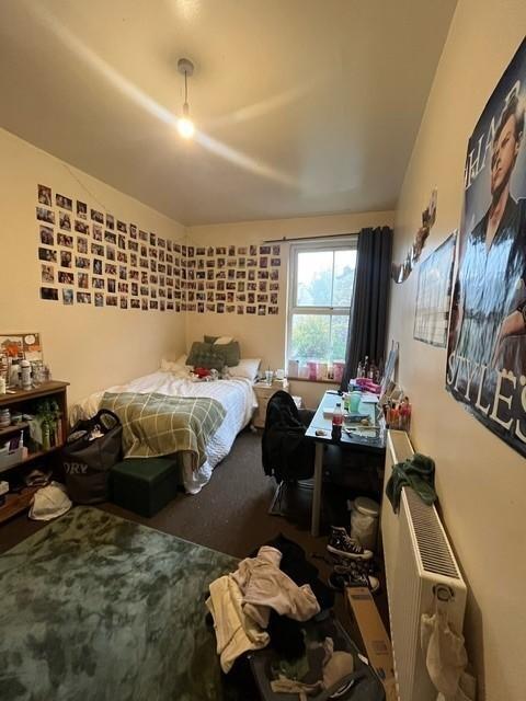 Spacious bedroom decorated with numerous photo ...