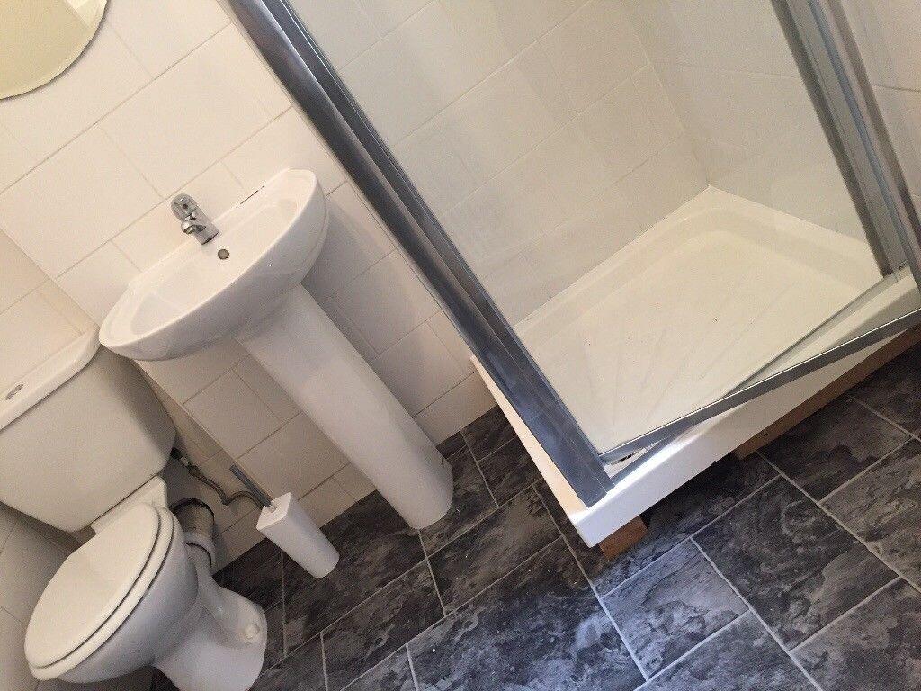 Bright, modern bathroom with a corner shower cu...