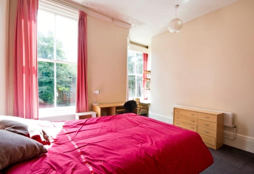 A bright and inviting double bedroom with large...