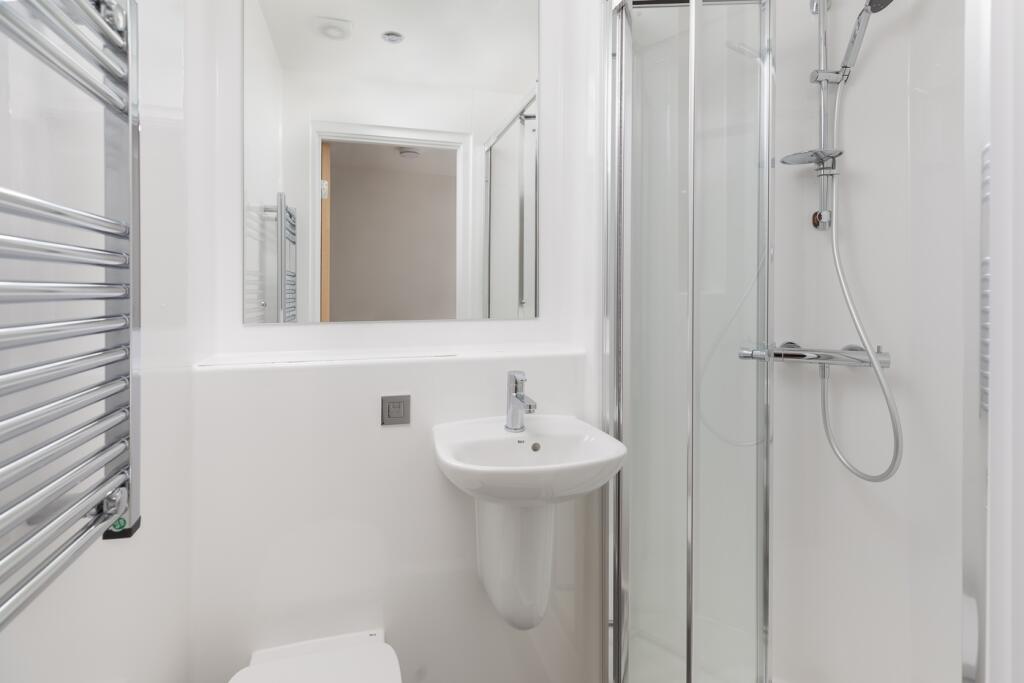 A modern and immaculate bathroom featuring a sl...