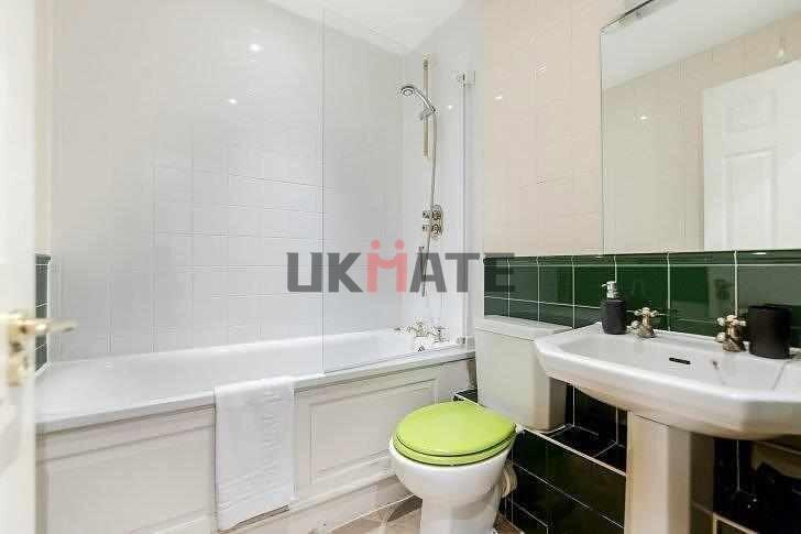 A clean and bright bathroom featuring a bathtub...