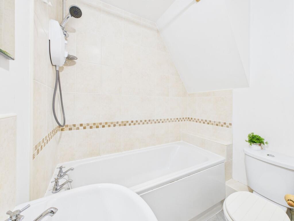 A clean and modern bathroom with a bathtub, toi...