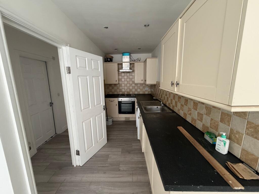 A functional kitchen with cream cabinetry and a...
