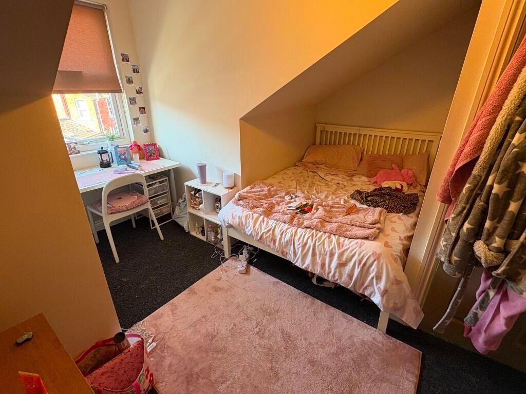 Cozy single bedroom featuring a comfortable bed...