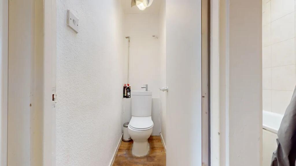 A compact and clean single toilet room with a m...