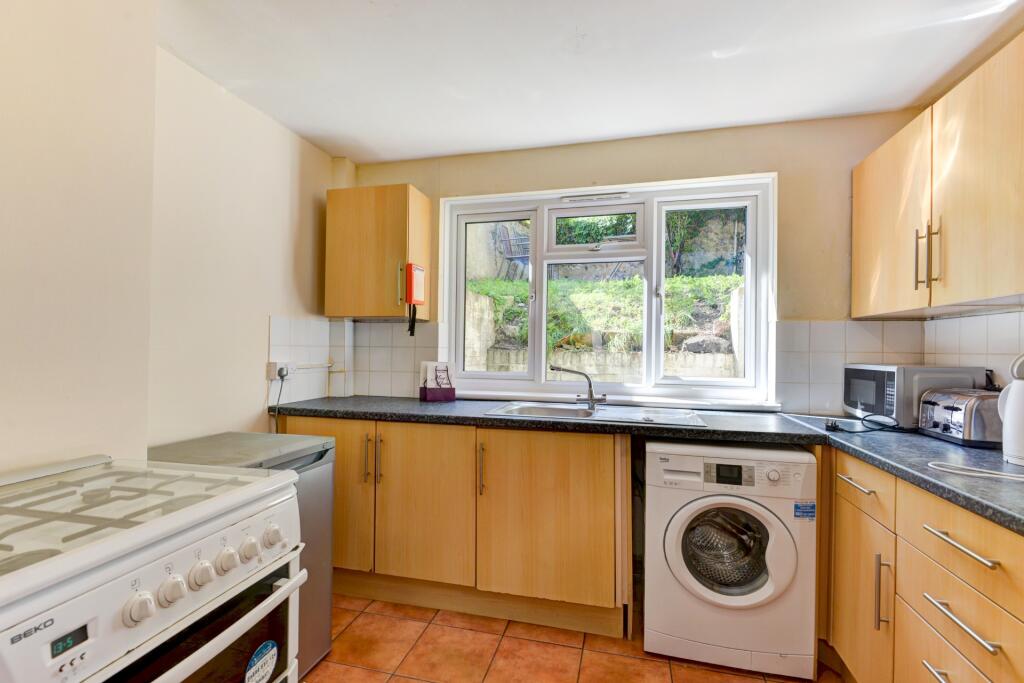 Bright and tidy kitchen featuring ample wooden ...