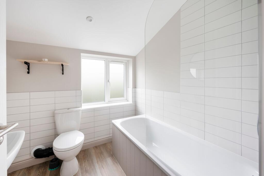 Bright, modern bathroom with a bathtub and show...