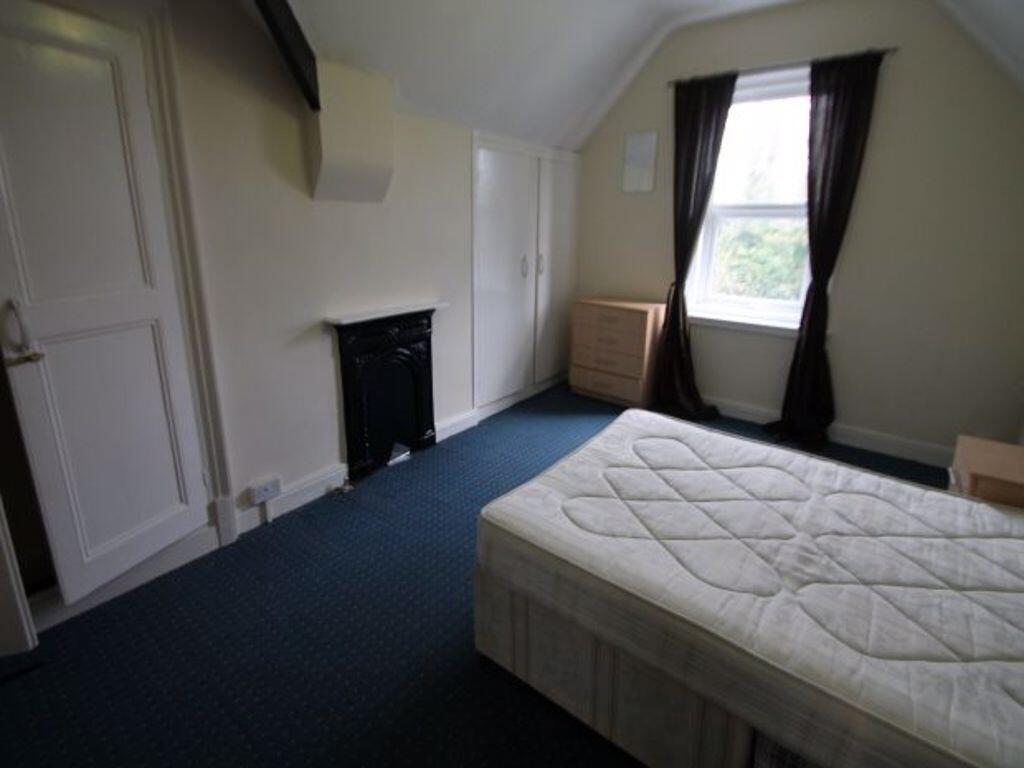 Bright, simply furnished bedroom with a double ...