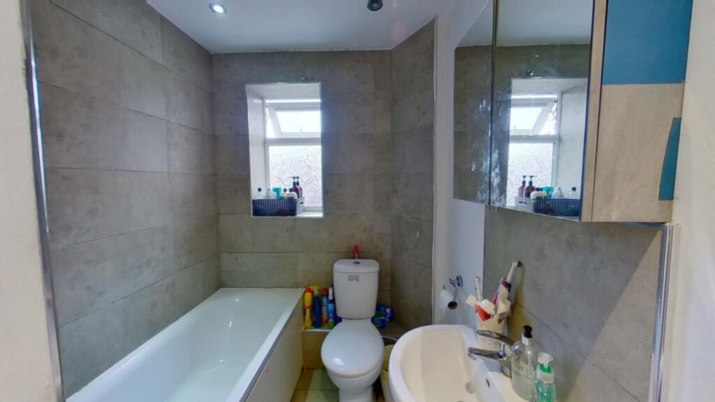 A modern bathroom featuring a bathtub and a tid...