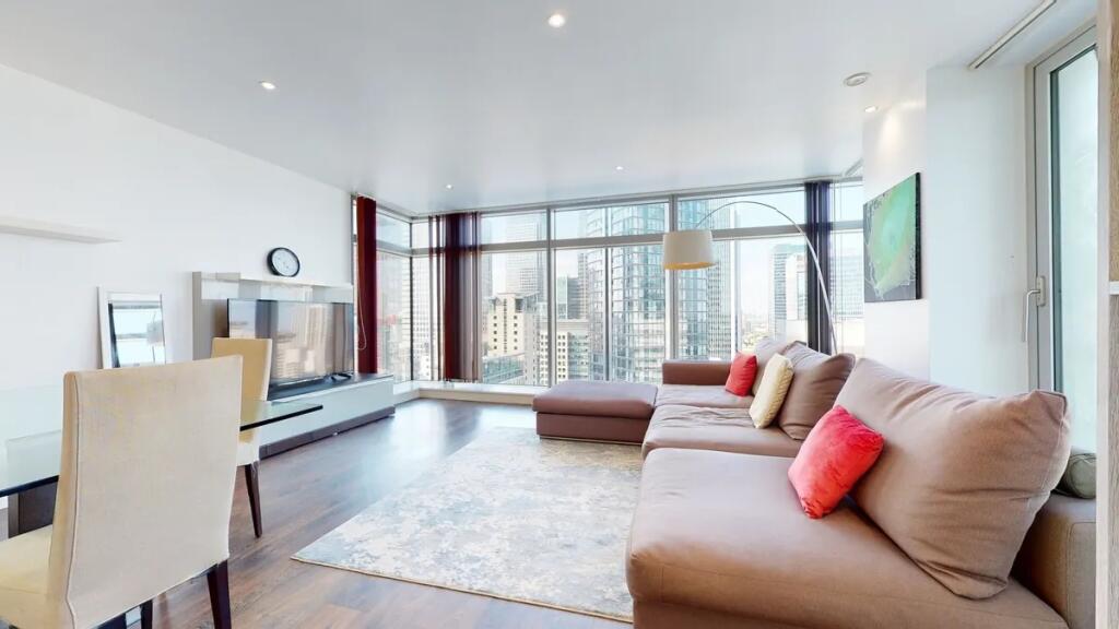 Bright and spacious living room featuring large...