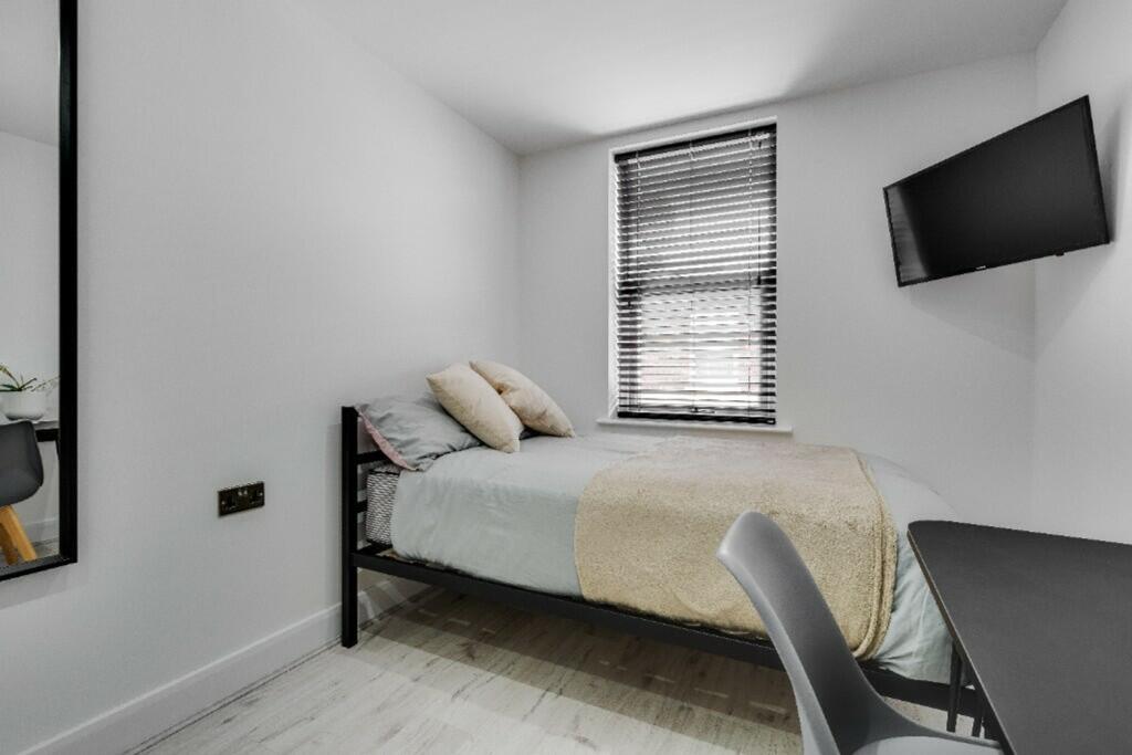 A bright and modern double bedroom featuring st...