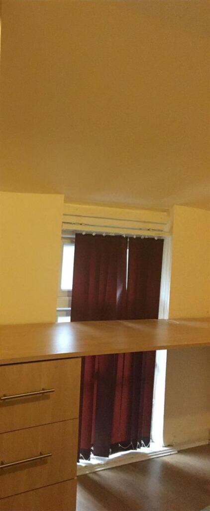 Small bedroom with built-in storage and a raise...