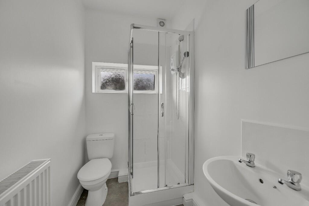 Bright and clean bathroom featuring a shower en...