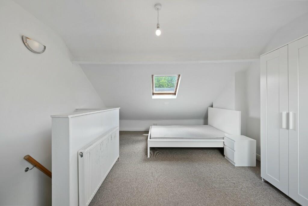 A bright and clean single bedroom with white wa...