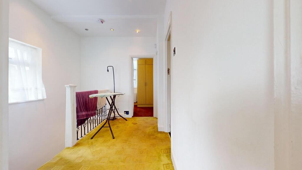 A bright hallway with clean white walls and a l...